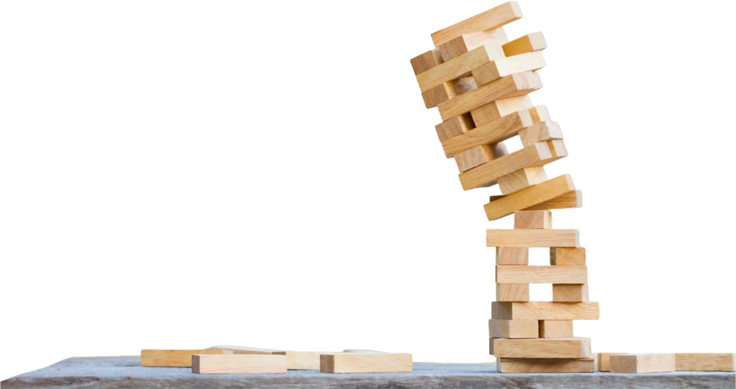 A wooden block tower, leaning badly on a table